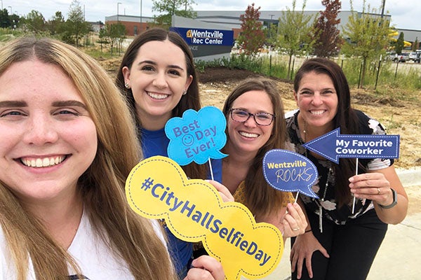 people taking a selfie with employee signs # city Hall Selfie Day