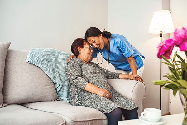 Nurse hugging elderly woman
