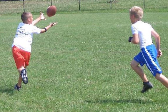 two boys playing football outside