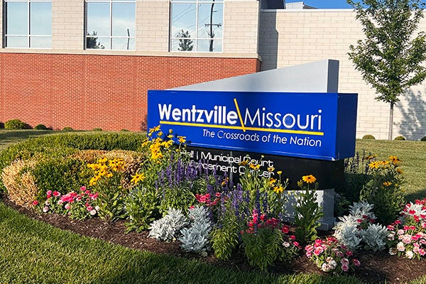city hall sign with flower bed