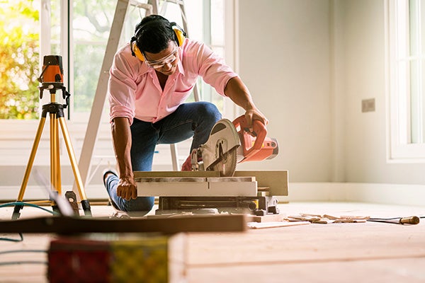 A homeowner uses a miter saw in his home for renovations