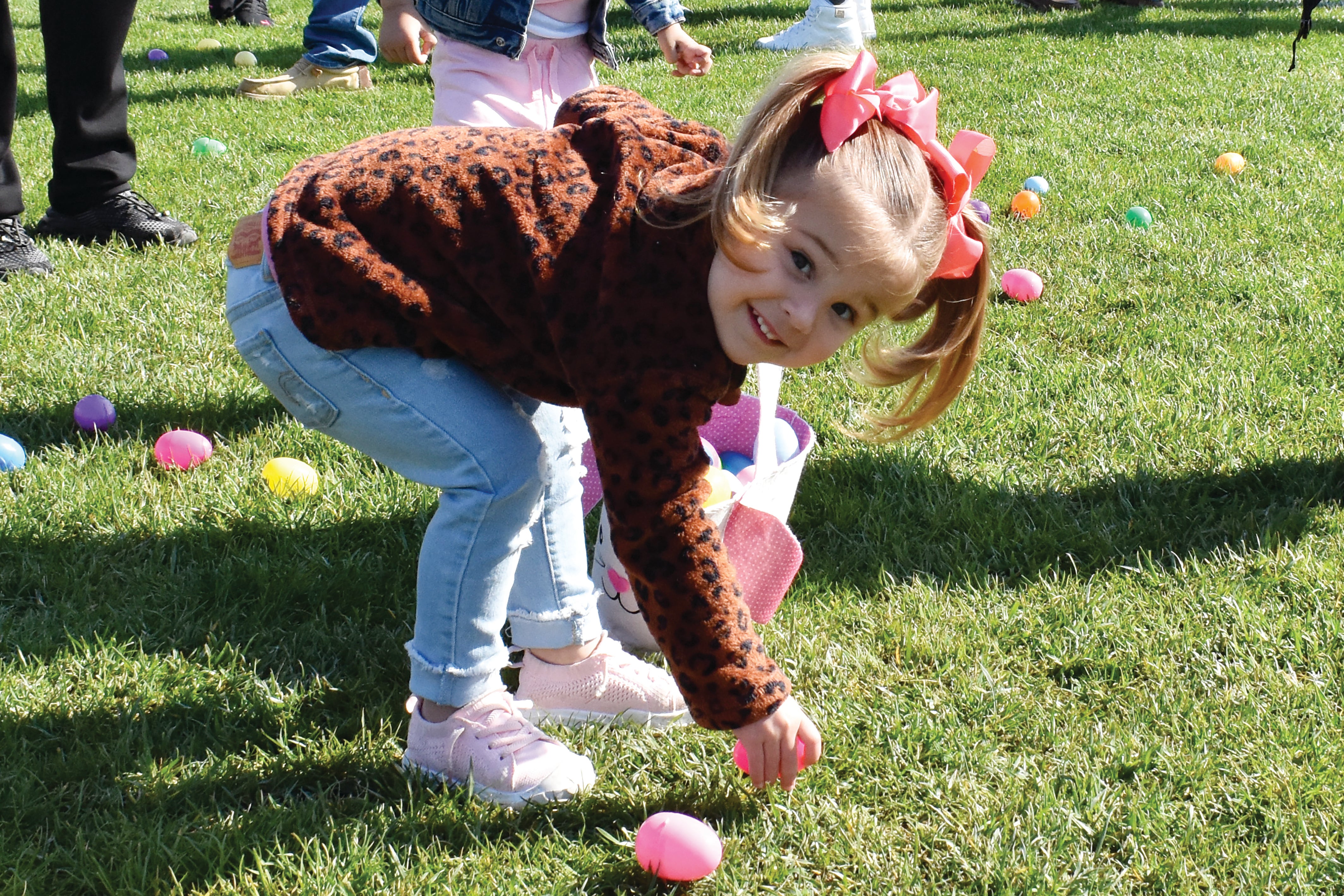 Young girl picking up Easter egg