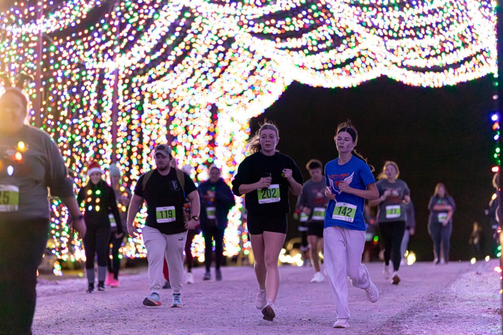 people running through light display