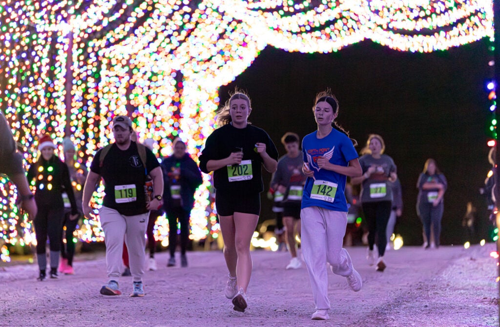 people running through light display