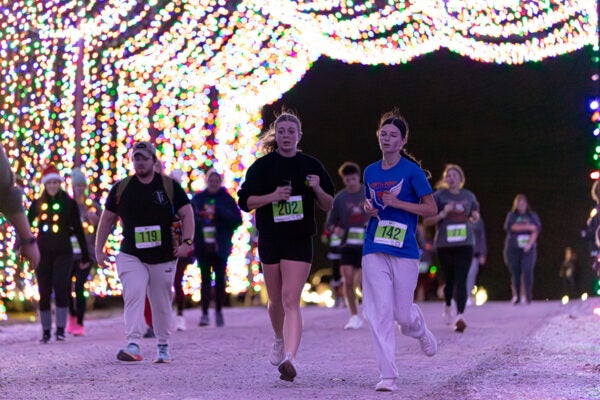 people running through light display