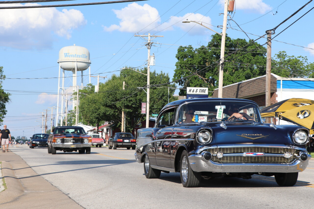 old car driving past Wentzville water tower