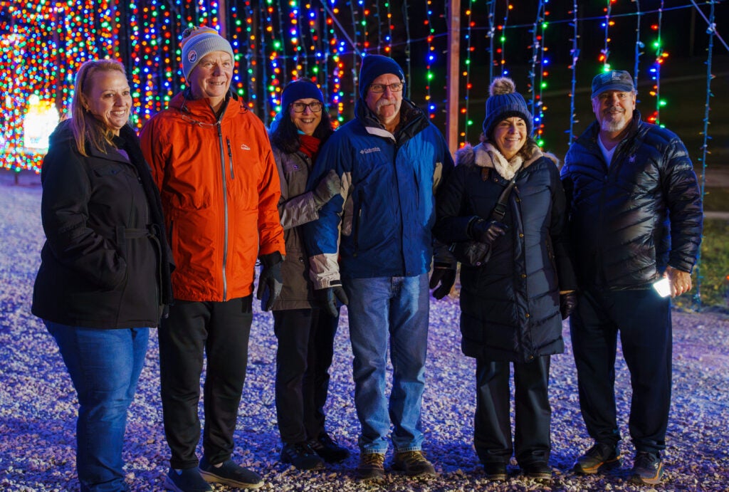 Group of adult standing together and smiling inside a light tunnel