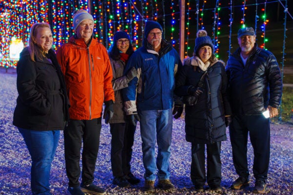 Group of adult standing together and smiling inside a light tunnel