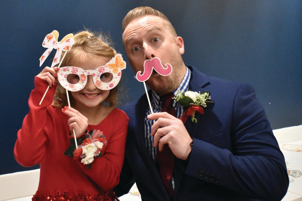 Father and daughter with photo prop glasses and a mustache