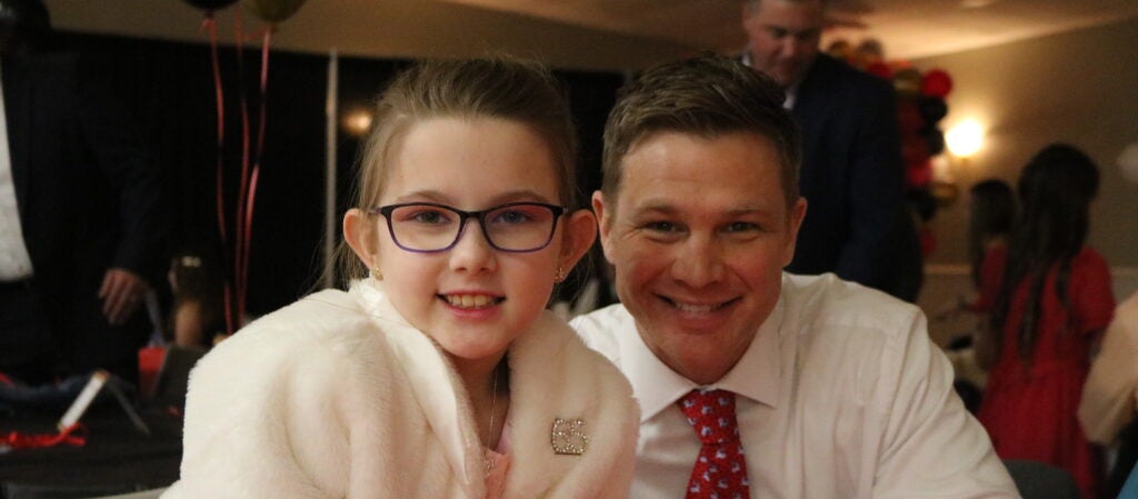 Father and daughter sitting at a table