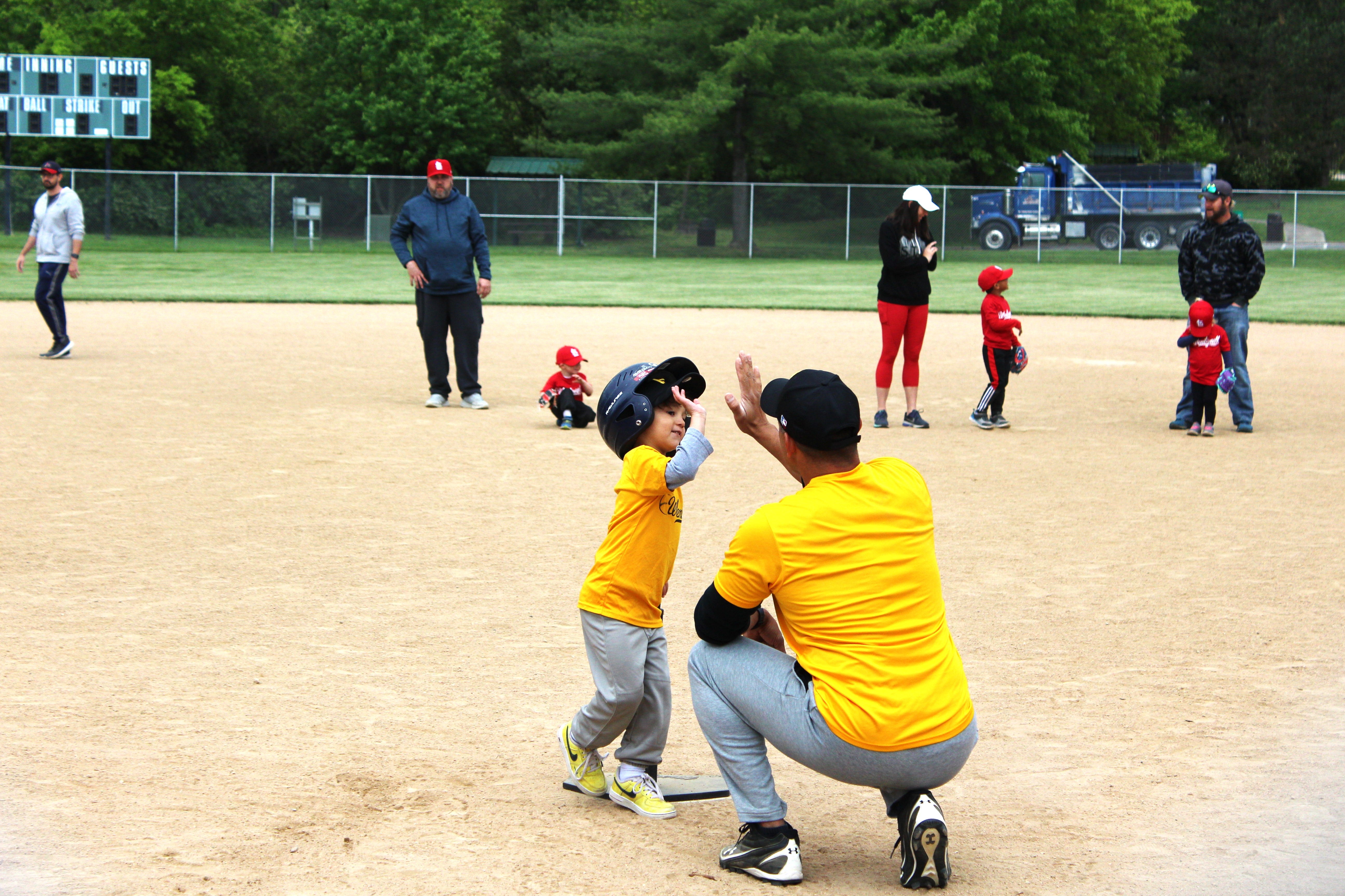 coach and young baseball player high-fiving
