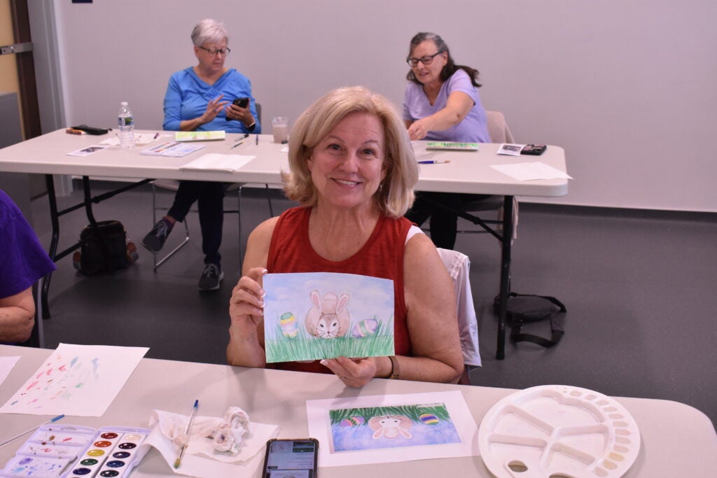 Woman holding watercolor painting