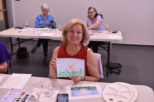 Woman holding watercolor painting