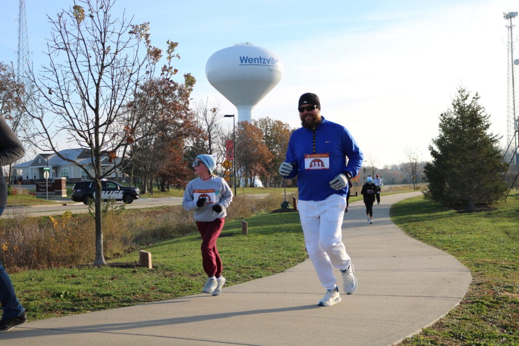 Man and boy running. Water tower in background