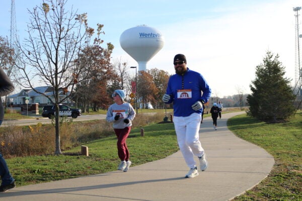 Man and boy running. Water tower in background