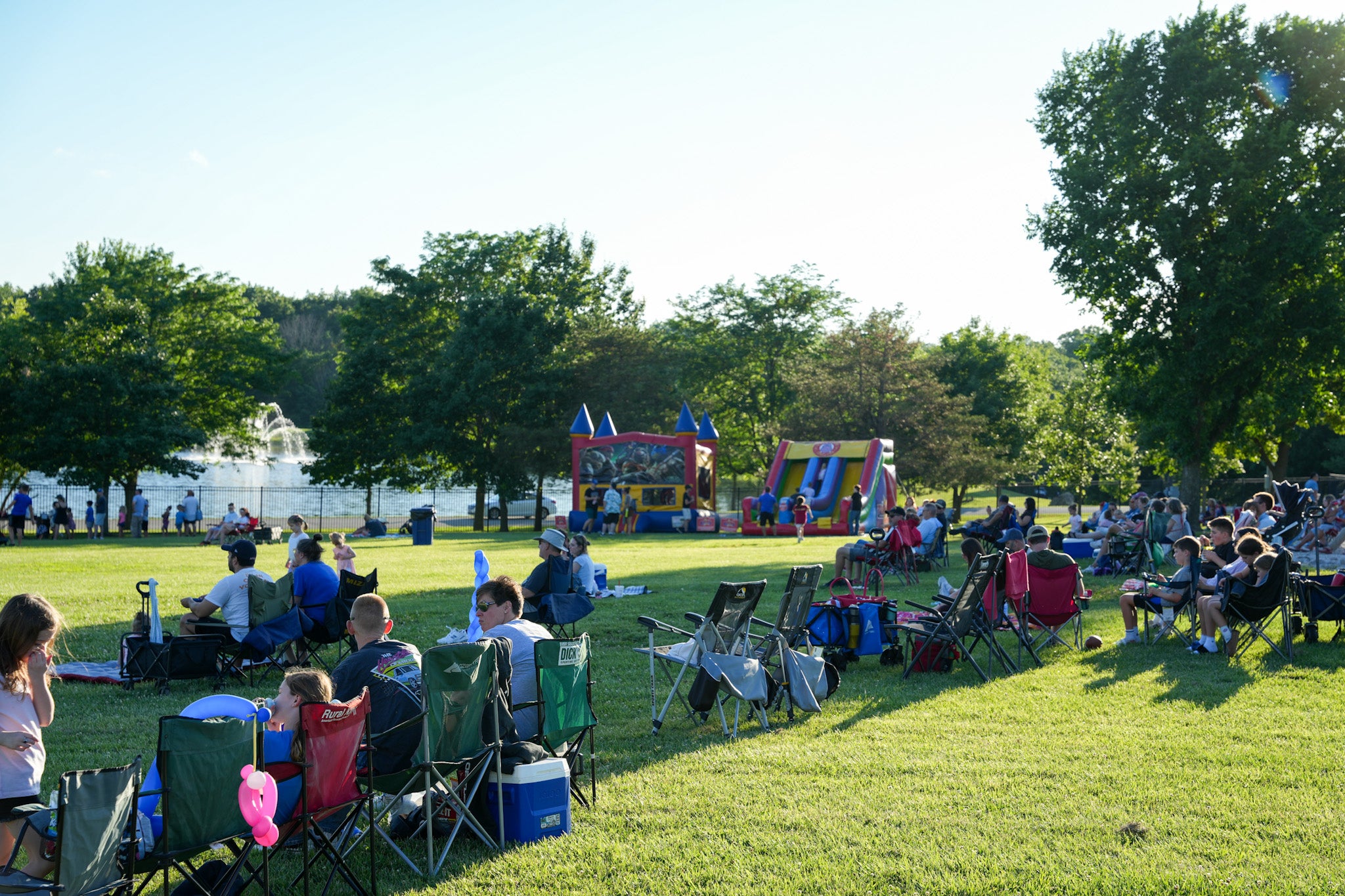Families sitting in lawn chairs lined up watching an outdoor concert